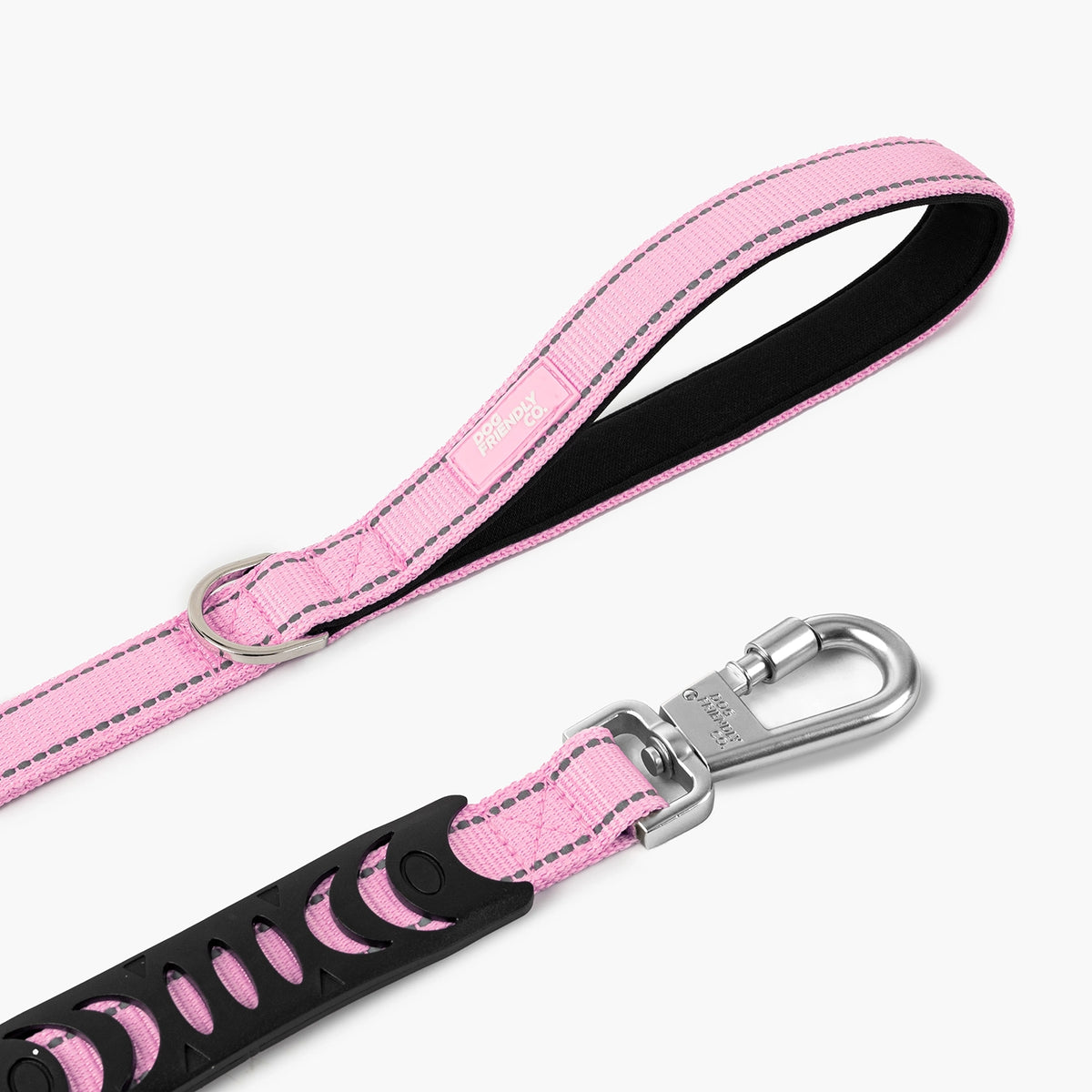 Close-up of a pink bungee dog leash showing the padded handle, metal D-ring and heavy-duty clip.
