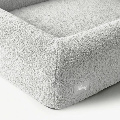 Grey Bouclé dog bed showing the soft textured cover and reinforced construction.